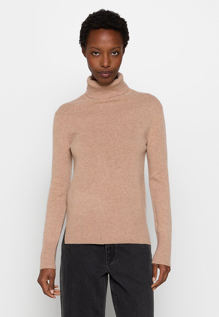 Beżowy sweter z golfem, wykonany z miękkiego dzianinowego materiału, z prążkowanymi mankietami i dołem, dopasowanym krojem oraz minimalnymi detalami.