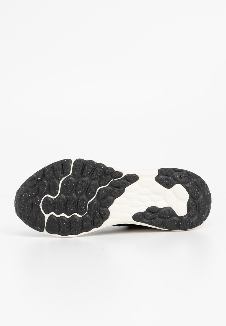 Schwarz-weiße Sport-Schuhsohle mit einer strukturierten Gumm-Oberfläche, die hexagonale Muster aufweist, sowie einem glatten zentralen Bereich für besseren Halt.