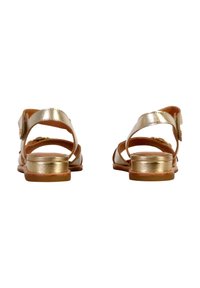 Guldmetalliske sandaler med T-stropdesign, flad hæl og justerbar spænde, med en glat læderoverflade og åben tå.