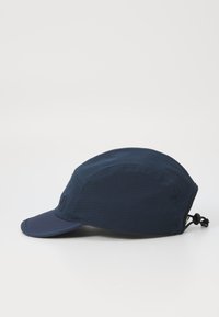 Navy blue cap made of lightweight fabric, featuring a visor, textured sides, and an adjustable strap at the back.