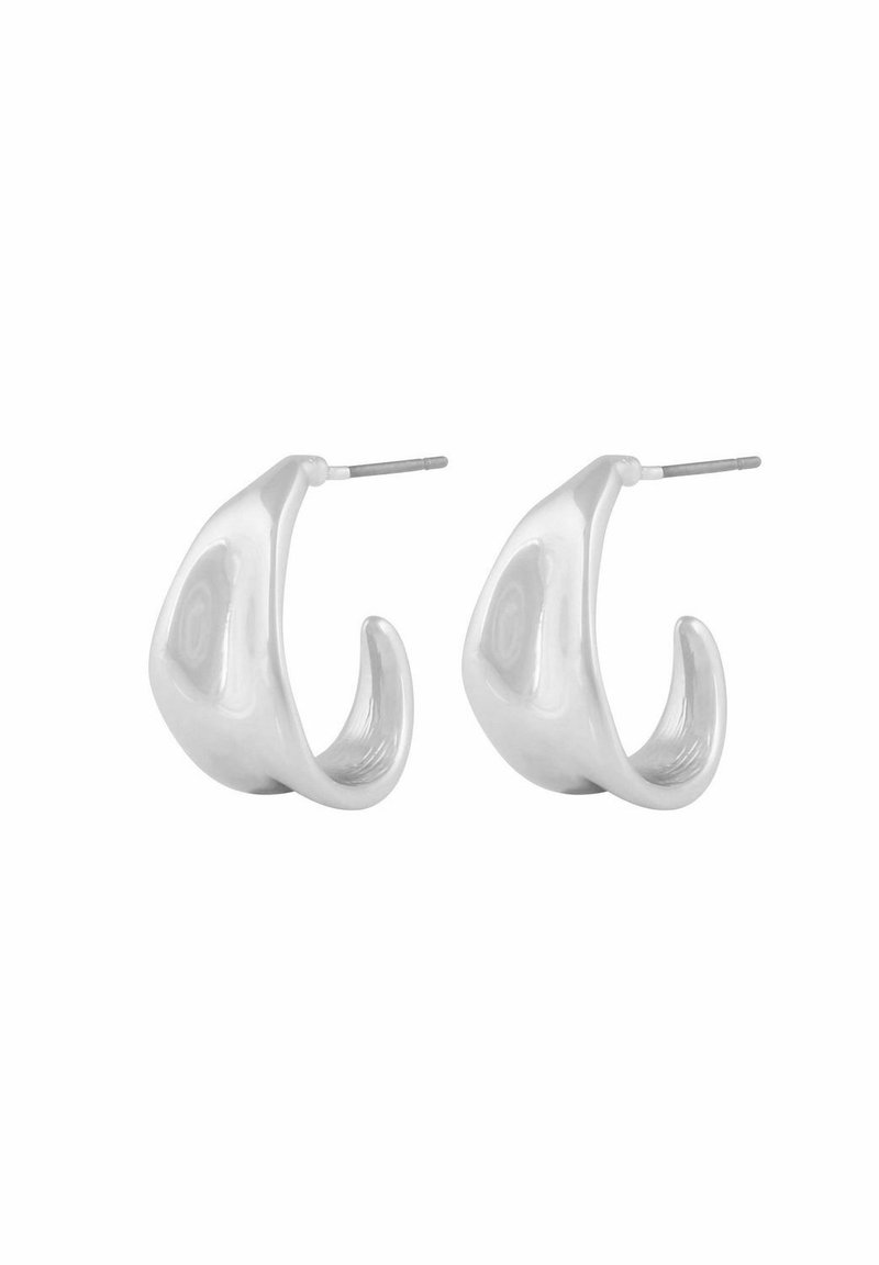 Ett par blanka silverfärgade hoops i oregelbundet mönster med stickbackar på en vit bakgrund.
