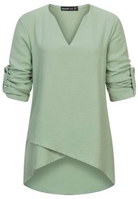 Maglietta verde chiaro a maniche lunghe con scollo a V, con maniche arrotolate fissate da bottoni. Orlo asimmetrico con una morbida consistenza.