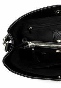 Interior de bolso negro con múltiples compartimentos, incluyendo un bolsillo con cremallera y una sección central con cremallera y detalles en hardware plateado.