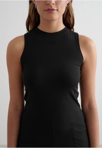 Czarny top bez rękawów wykonany z gładkiego materiału, z okrągłym dekoltem i delikatnym logo marki na piersi, zaprojektowany dla dopasowanej sylwetki.