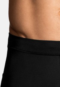 Korte sorte sportshorts med en glat textile, der har en tætsiddende pasform og en elastisk talje. Shortsene har minimal syning.