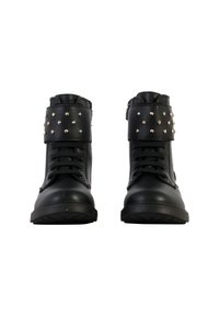 Botas de tobillo de cuero negro con puntera redonda, que cuentan con una correa con hebilla y tachuelas metálicas decorativas en la parte superior. Suela de goma texturizada.