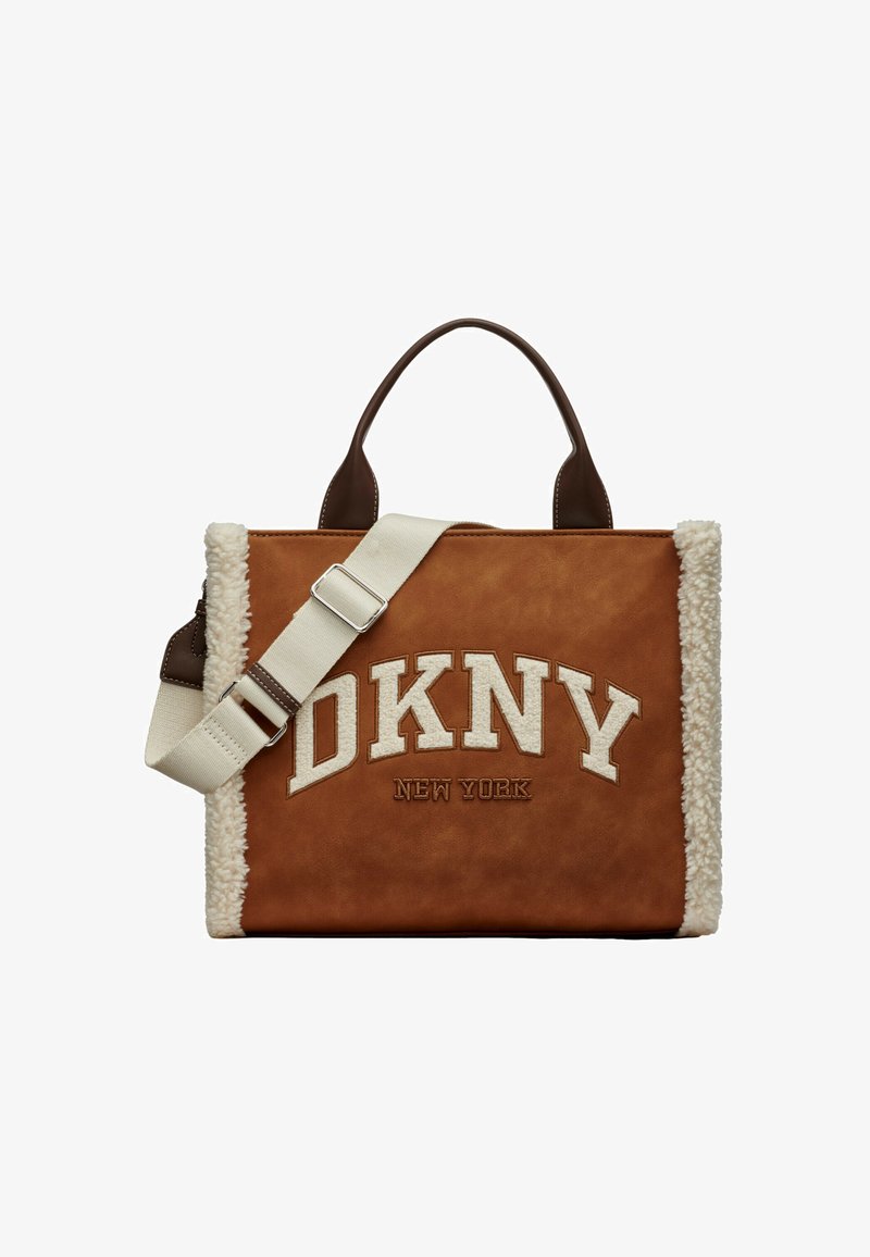 Sac cabas en similicuir marron avec des accents en peau lainée crème, présentant un logo DKNY blanc et une bandoulière beige amovible.