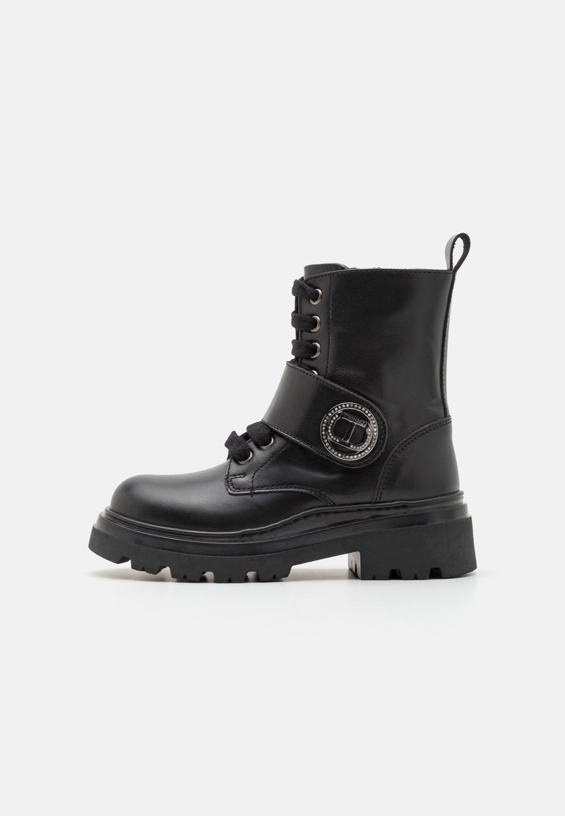 Black leather ankle boot with a chunky sole, lace-up design, decorative circular hardware, and a reinforced heel for stability.