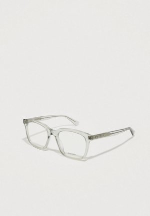 Óculos de acetato transparentes com armação quadrada, apresentando hastes finas e um logótipo gravado. Acabamento transparente sem padrões visíveis.