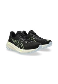 Zwarte sportieve schoenen met een lichtgewicht mesh bovenwerk, opvallende geel-groene accenten en een gewatteerde witte tussenzool. Voorzien van veters en een flexibele buitenzool.