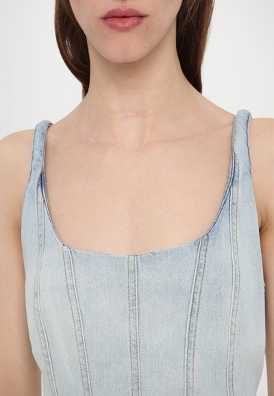 Hellblaues Denim-Oberteil mit quadratischem Ausschnitt und breiten Trägern. Verfügt über vertikale Nähte und eine leicht strukturierte Oberfläche.