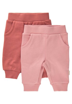 Twee paren peuter sweats, één in roestig rood en één in lichtroze. Beide hebben elastische taillebanden en zijzakken. Zacht, ribbelig textuur.