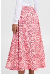 Jupe à motifs rose et blanche avec un design en A-line évasé, taille élastique, présentant des motifs de diamants et floraux. Tissu doux et léger.