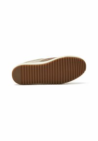 Smeđi potplat tenisice s teksturiranim, rebrastim uzorkom. Bijeli midsole u kontrastu s gumenim potplatom. Dizajn ima ležeran, nisko-profilirani oblik.