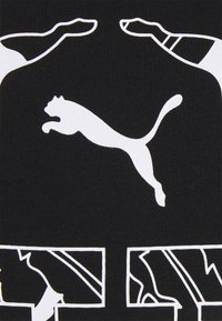 Bílý skákající puma logo se stylizovanými rukama a nohama obrysem nahoře a dole, vše na černém texturovaném pozadí.