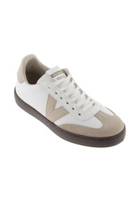 Sneakers avec une tige en cuir blanc et des accents en daim beige, bout rond, semelle en caoutchouc marron contrastante et lacets blancs.