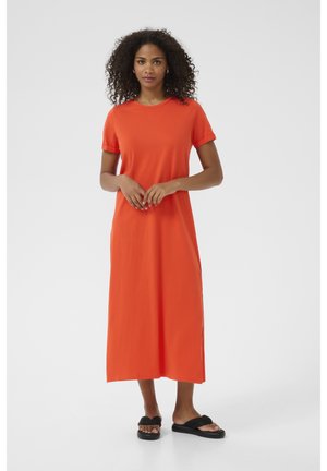 Orange maxi dress with short sleeves, crew neck, and side slits. Made of soft fabric; model wearing black sandals. Simple, minimal design.