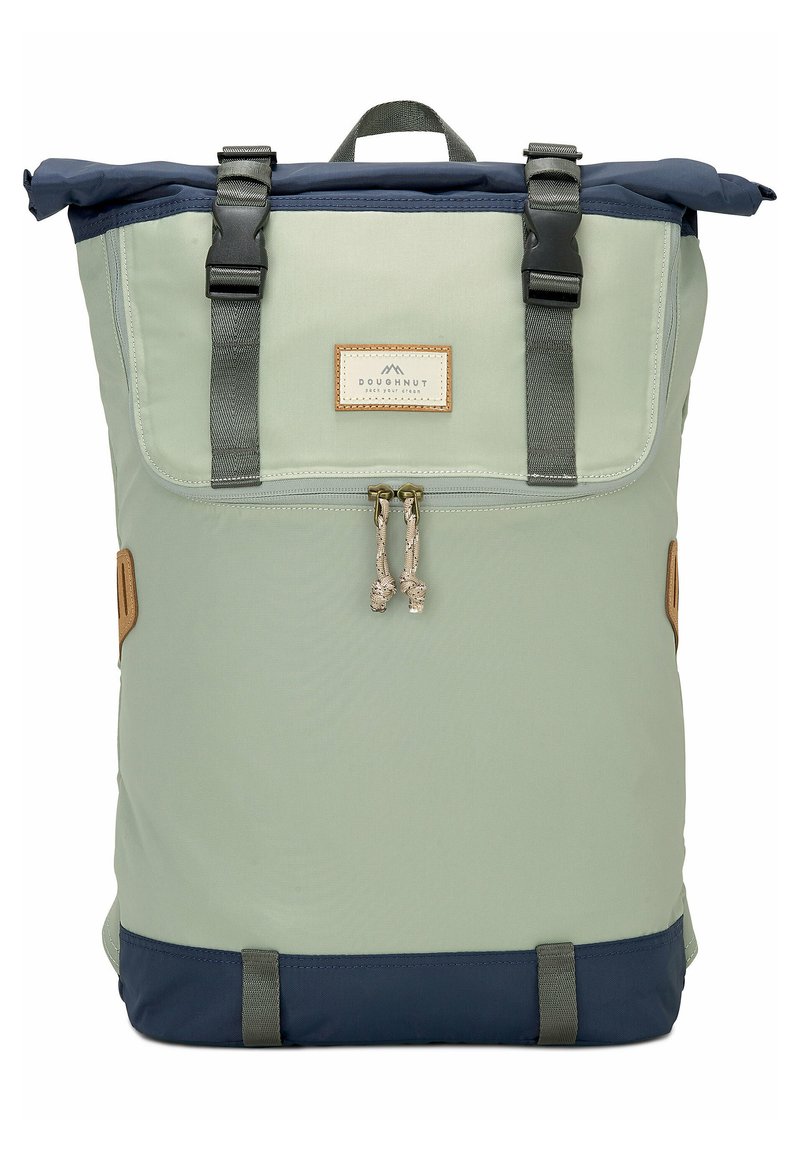 Grüner Rolltop-Rucksack mit navyfarbenem Boden, verstellbaren Trägern, Lederakzenten und einer vorderen Reißverschlusstasche mit dekorativen Ziehgriffen.