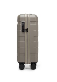 Valigia rigida in beige texturizzato con lucchetto combinato, due grandi ruote nere e scanalature verticali per stabilità e presa.
