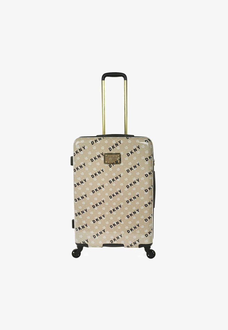Maleta rígida en beige con impresión del logo negro de DKNY. Cuenta con un mango telescópico dorado, cuatro ruedas giratorias y detalles en negro.