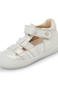 Srebrne metaliczne buciki dziecięce z zapięciem na pasek, otwartym designem i białą gumową podeszwą. Posiadają poziome i pionowe nacięcia.