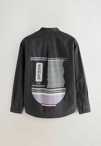 Čierna košeľa s dlhým rukávom, na zadnej strane veľký grafický motív misky ramenu v odtieňoch fialovej, bielej a čiernej. Manžety so zapínaním na gombíky a klasický golier.