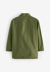 Giacca verde oliva, a maniche lunghe, con un colletto semplice, tessuto liscio e polsini con bottoni; presenta un design pulito e minimalista.