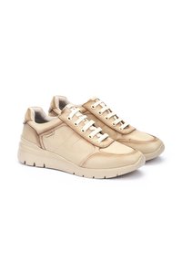 Zapatillas de cuero beige con punta redonda, diseño de cordones, cuello acolchado y paneles de acento texturizados en los laterales. Suela de goma.