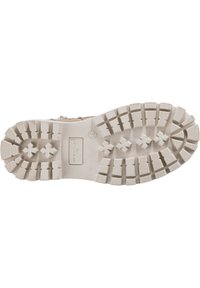 Semelle de chaussure beige avec des profondeurs de semelle, des motifs de traction en forme de croix, et le nom de marque "Tom Tailor" embouti, taille 31 visible.