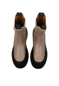 Beige and black ankle boots made of smooth synthetic material, featuring a round toe, textured sole, and fabric pull tabs at the top.