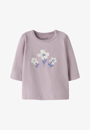 Camiseta de manga larga lila hecha de algodón, con un diseño frontal de tres flores en blanco y azul claro con tallos verdes.