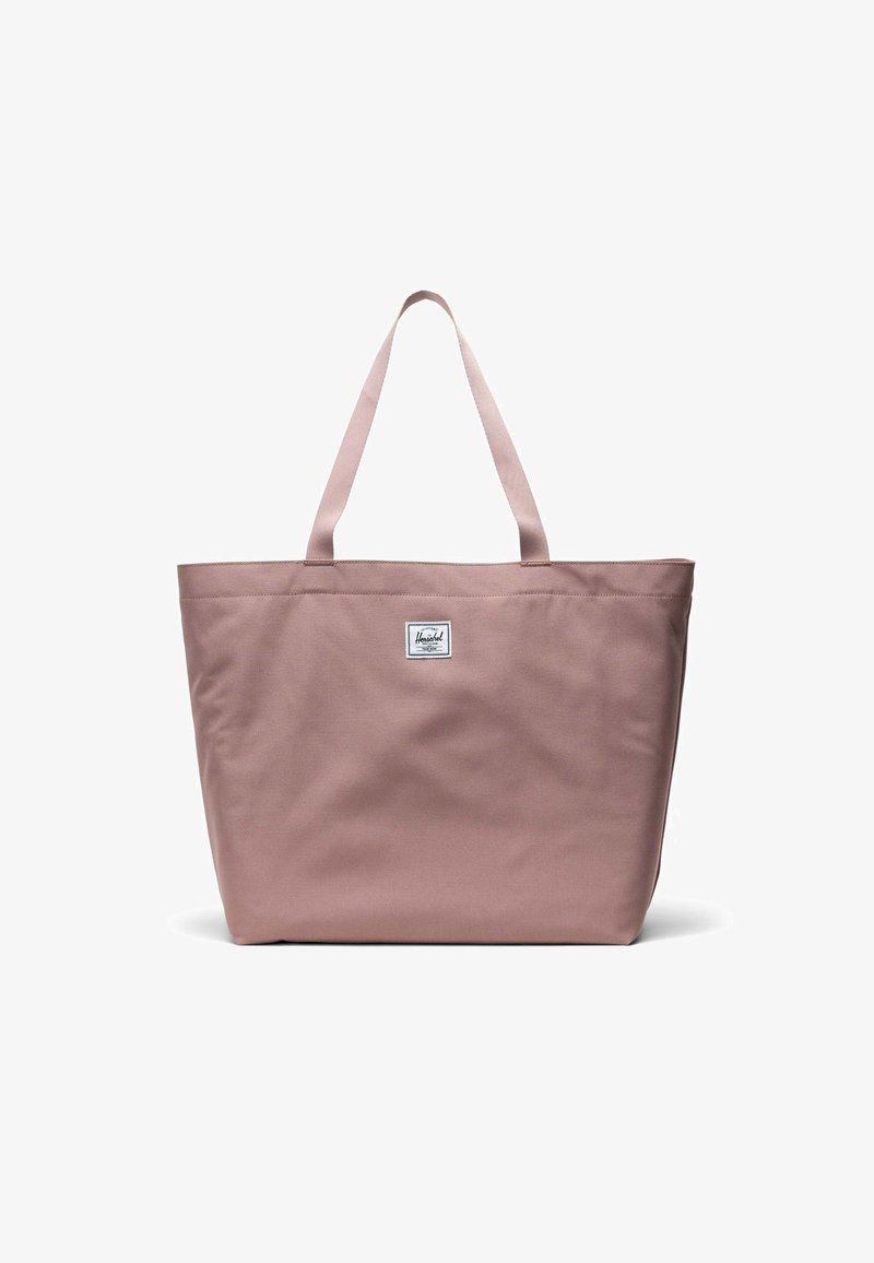 Różowa torba płócienna z dwiema rączkami na ramię, prostokątny kształt i naszywka z logo z przodu. Materiał o gładkiej strukturze i trwałej konstrukcji.
