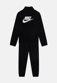 Mustast Nike'i treeningülikond, millel on pikkade varrukatega topp kõrge kraega ja silmatorkav valge logo, koos vastava elastse vöökohtadega pükste paariga.