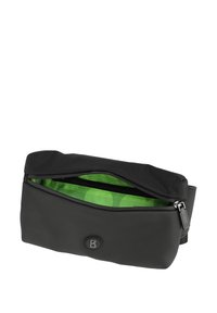 Borsa in silicone nera con chiusura a zip, con un rivestimento interno a pois verdi e un logo rotondo sul davanti. Texture liscia.