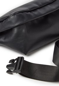 Borsa in pelle nera con apertura a pieghe, caratterizzata da una superficie testurizzata e una tracolla nera removibile con accessori in plastica.