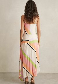 Robe maxi en tissu léger avec des rayures diagonales rose, vert et orange ; présente des fines bretelles et une silhouette fluide.