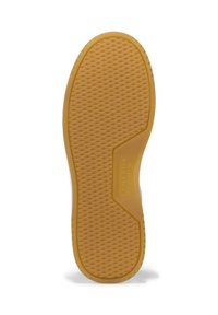 Suela de un zapato marrón claro con un dibujo de tracción en forma de diamante y la marca "Cole Haan Grand.OS" en la zona del arco.