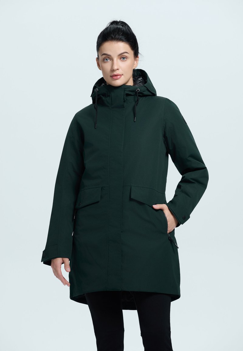 Parka de color verde oscuro, impermeable, con capucha, cierre frontal de cremallera y broches a presión, grandes bolsillos y cordones ajustables.