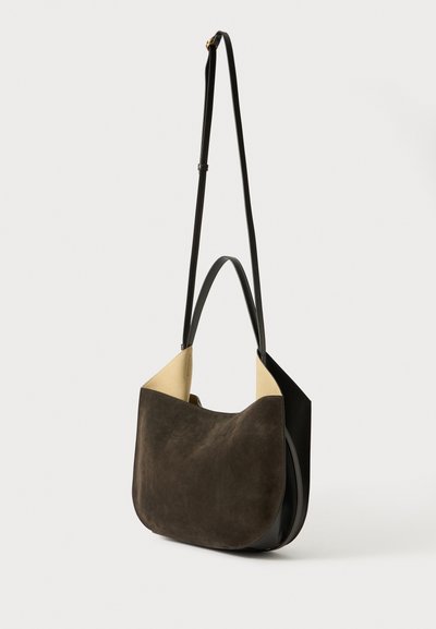 Borsa a mano in suede marrone scuro con forma arrotondata, dettagli in pelle e un interno chiaro in contrasto. Tracolla regolabile per un trasporto versatile.