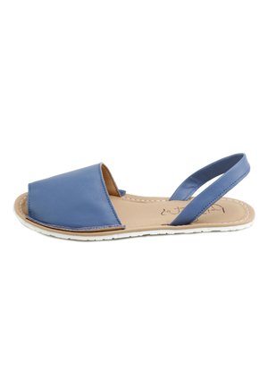 Sandalia plana de cuero azul con puntera abierta, tira frontal ancha y tira trasera en suela beige con costura blanca y suela de goma.