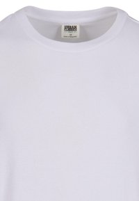 T-shirt din bumbac organic alb cu textură în relief, guler rotund și căptușeală cusută. Eticheta spune "Urban Classics", mărimea M.