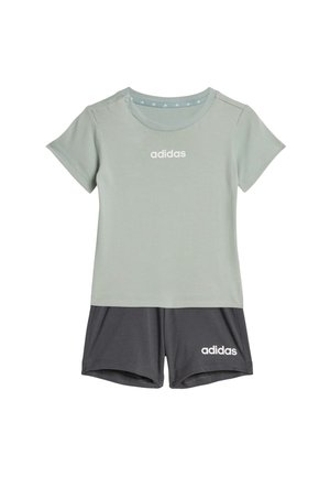 Maglietta Adidas a maniche corte verde chiaro con logo bianco abbinata a pantaloncini Adidas grigio scuro con logo bianco sulla gamba sinistra.