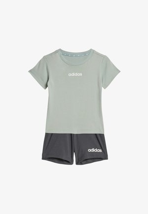 Camiseta Adidas de manga corta verde claro con logo blanco combinada con pantalones cortos Adidas gris oscuro con logo blanco en la pierna izquierda.