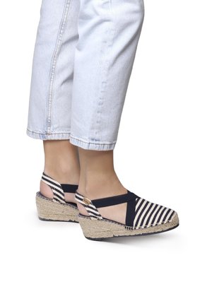Wedge sandals with a striped navy and white fabric upper, featuring cross-strap design, espadrille-style woven jute platform, and a rubber sole.