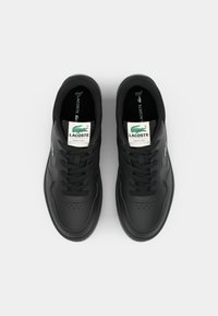 Μαύρα αθλητικά sneakers με λείο δέρμα, στρογγυλή μύτη και επίπεδους κορδόνια. Διαθέτει ετικέτα λογότυπου στη γλώσσα και διακριτή ραφή.