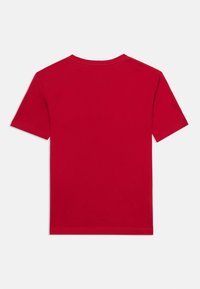 Plain red short-sleeve T-shirt laid flat showing the back with a round neckline and visible stitching on sleeves and hem.