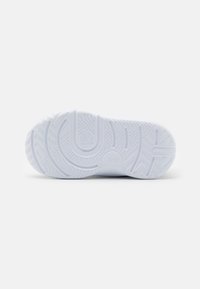 Witte sneakersole met gestructureerd rubber, met een golfpatroon en het Nike-logo. Het ontwerp omvat een geribbelde loop zodat er grip is.