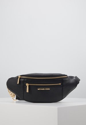 Czarna skórzana nerka Michael Kors z dwoma złotymi zamkami i łańcuszkiem, spoczywająca na białym piedestale na neutralnym tle.