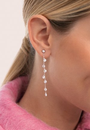 Pendientes de gota plateados con múltiples acentos de piedras preciosas claras, que presentan un diseño delicado de cadena colgando de un clavo.