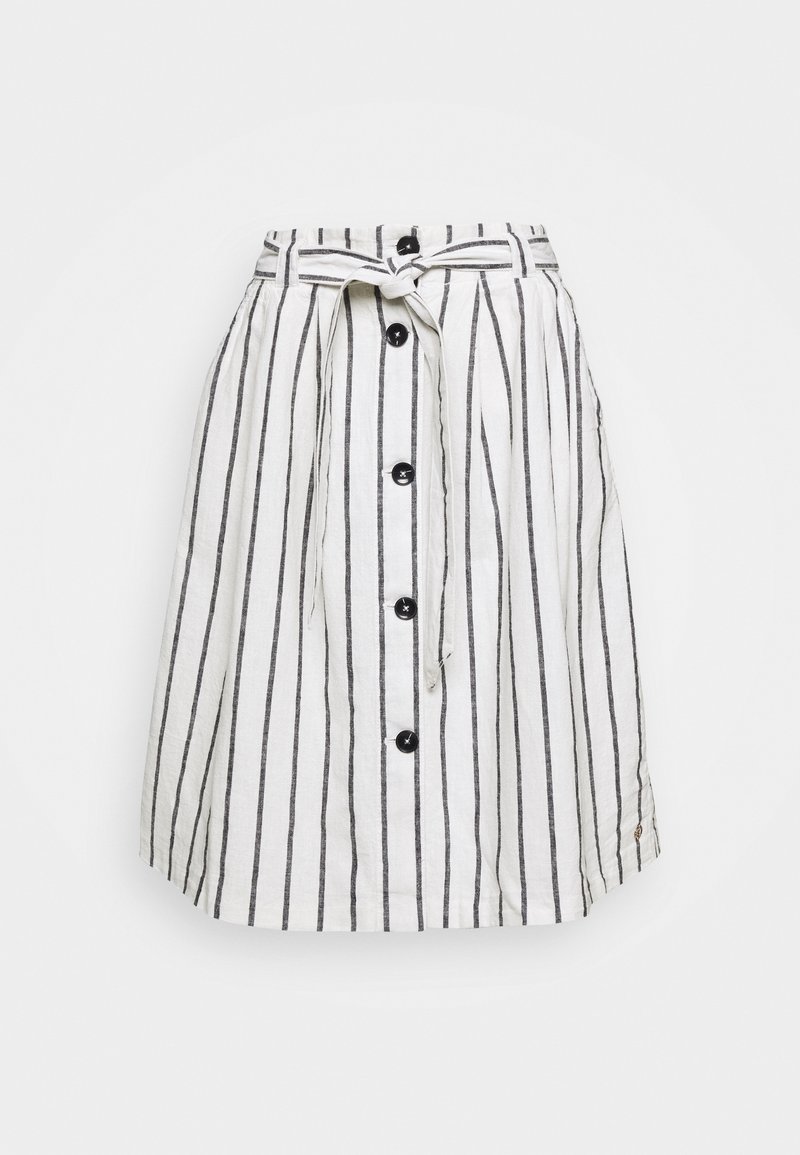 Jupe blanche à rayures noires verticales, boutons sur le devant et ceinture en tissu nouée à la taille, présentée sur un fond uni.